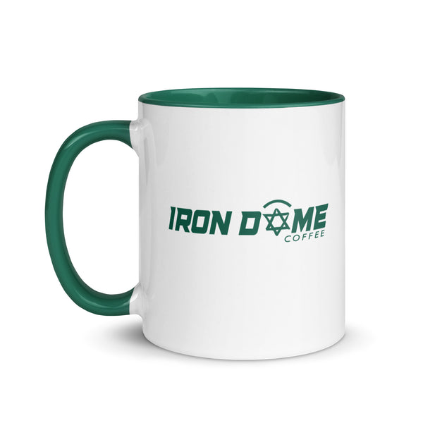 A ceramic coffee mug with a green rim, handle, and interior, featuring the 'Iron Dome Coffee' logo on the exterior.